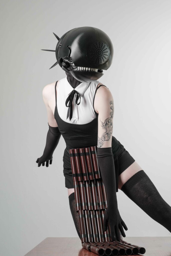 Bomb Devil holding a book. button over the image that says details. The button will take you to a place that will talk about the making of the Bomb Devil cosplay