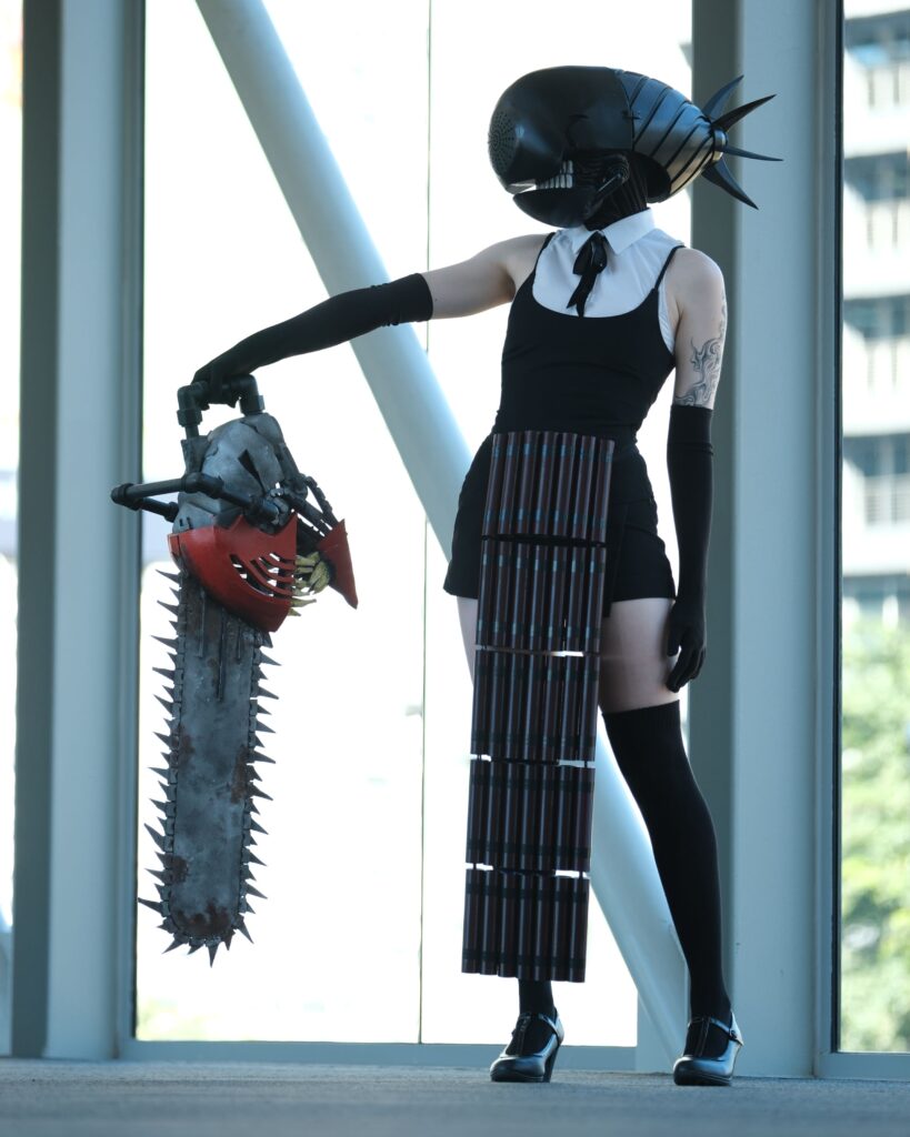 Bomb Devil cosplayer holding chainsaw mans head from chainsaw man.