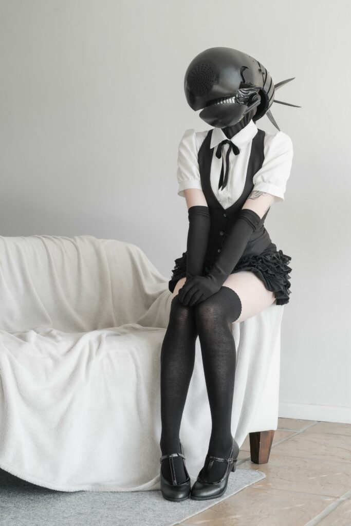 Bomb devil cosplay sitting on end of couch